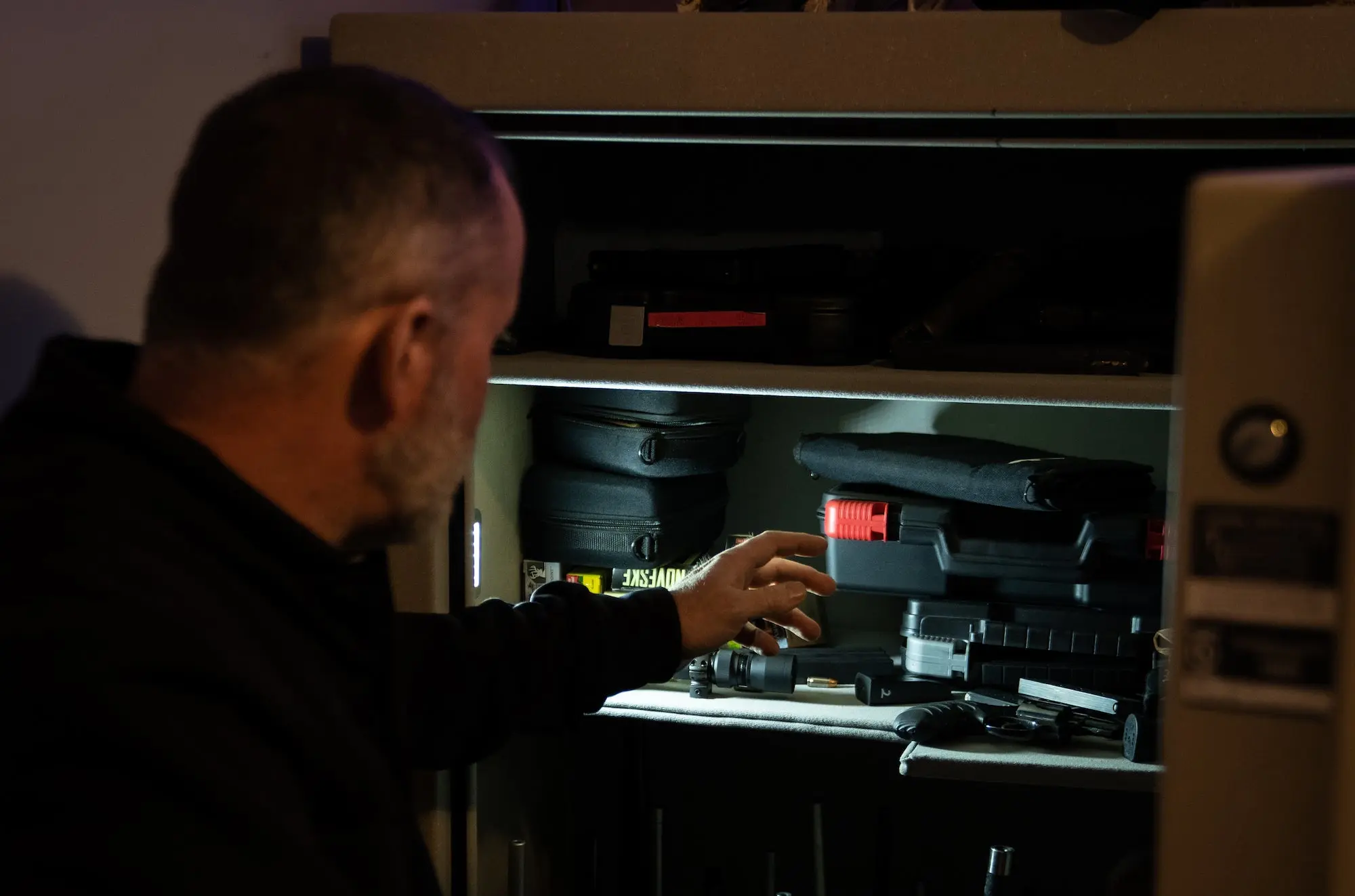 Man reaching into a gun safe.