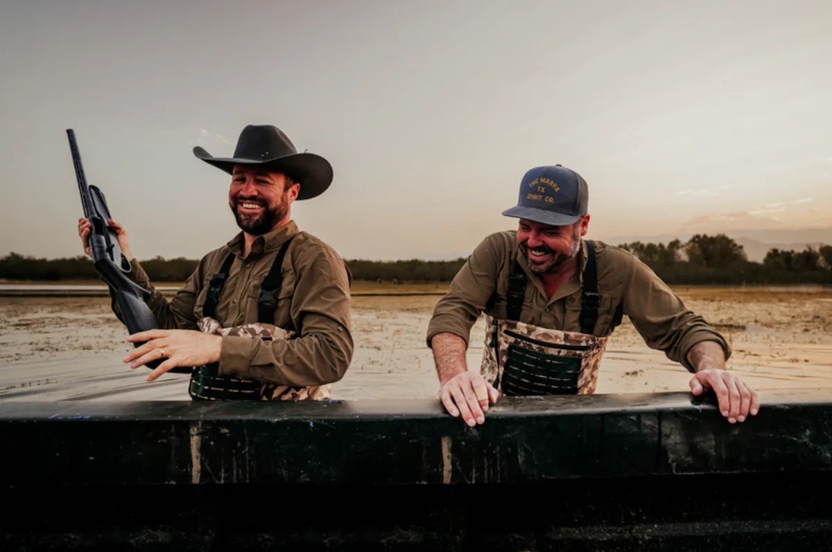 Two hunters standing in a blind wearing Duck Camp waders