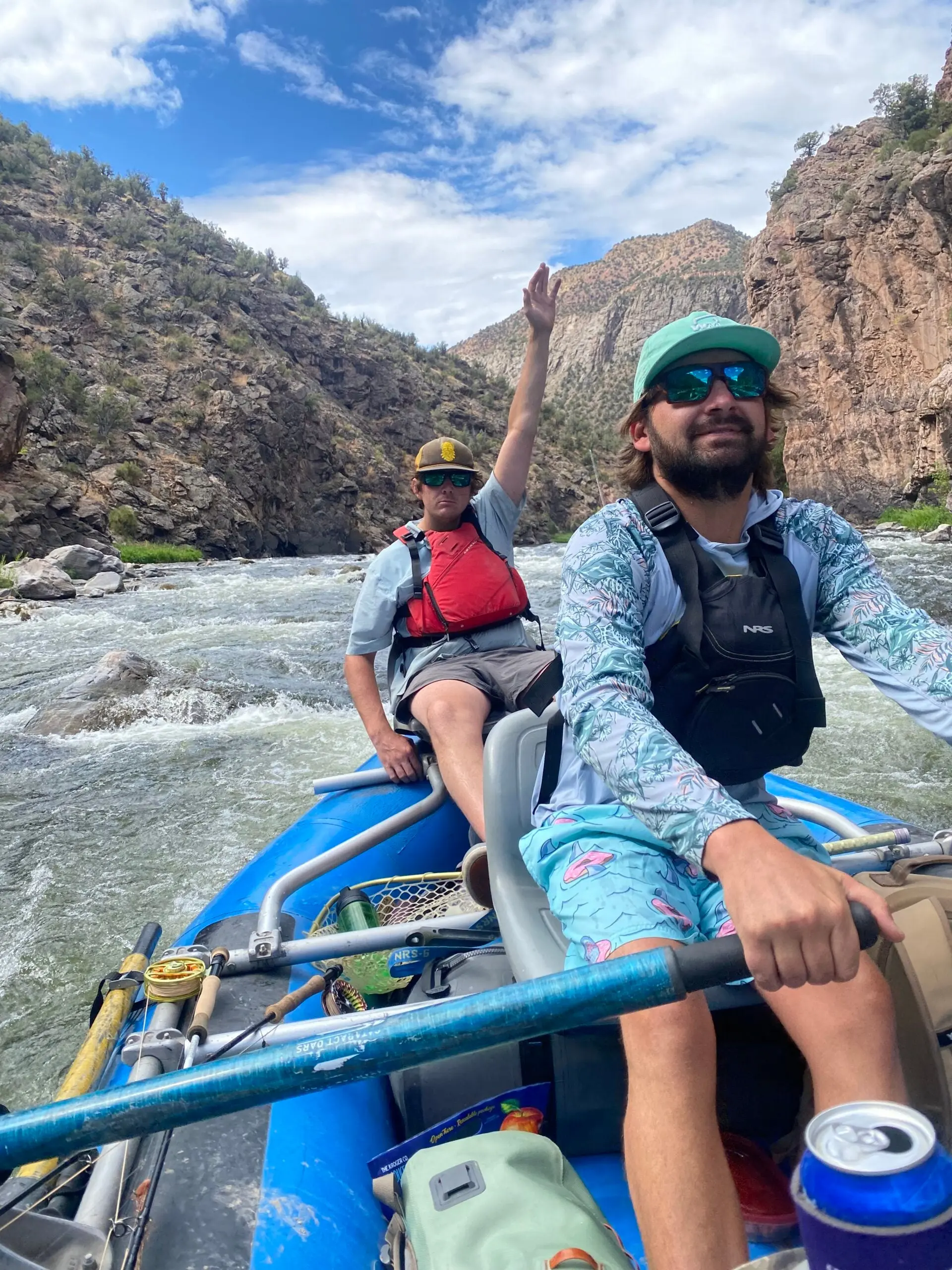 Two fishermen rowing a raft down a river