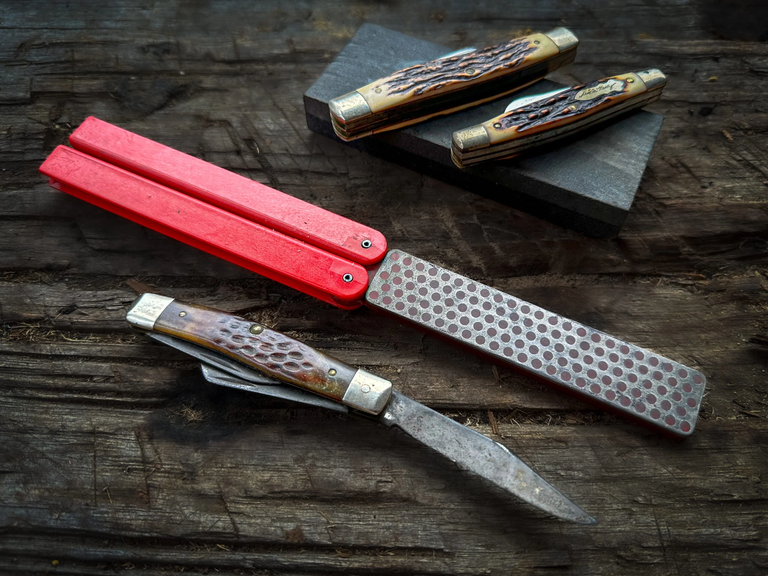 Three pocket knives and a diamond file sharpener