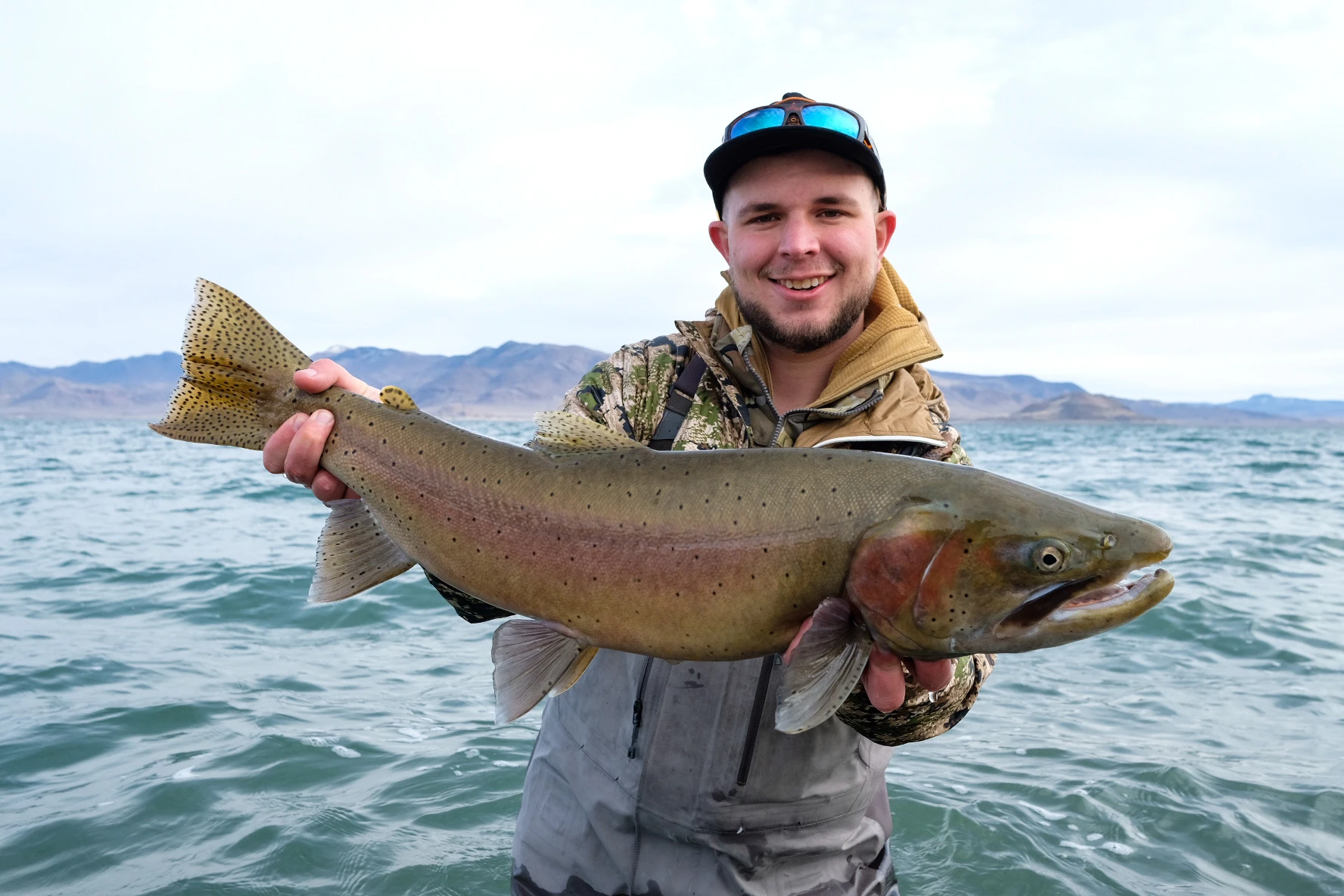 Angler holding up big cutthroat trout in Pyramid Lake.