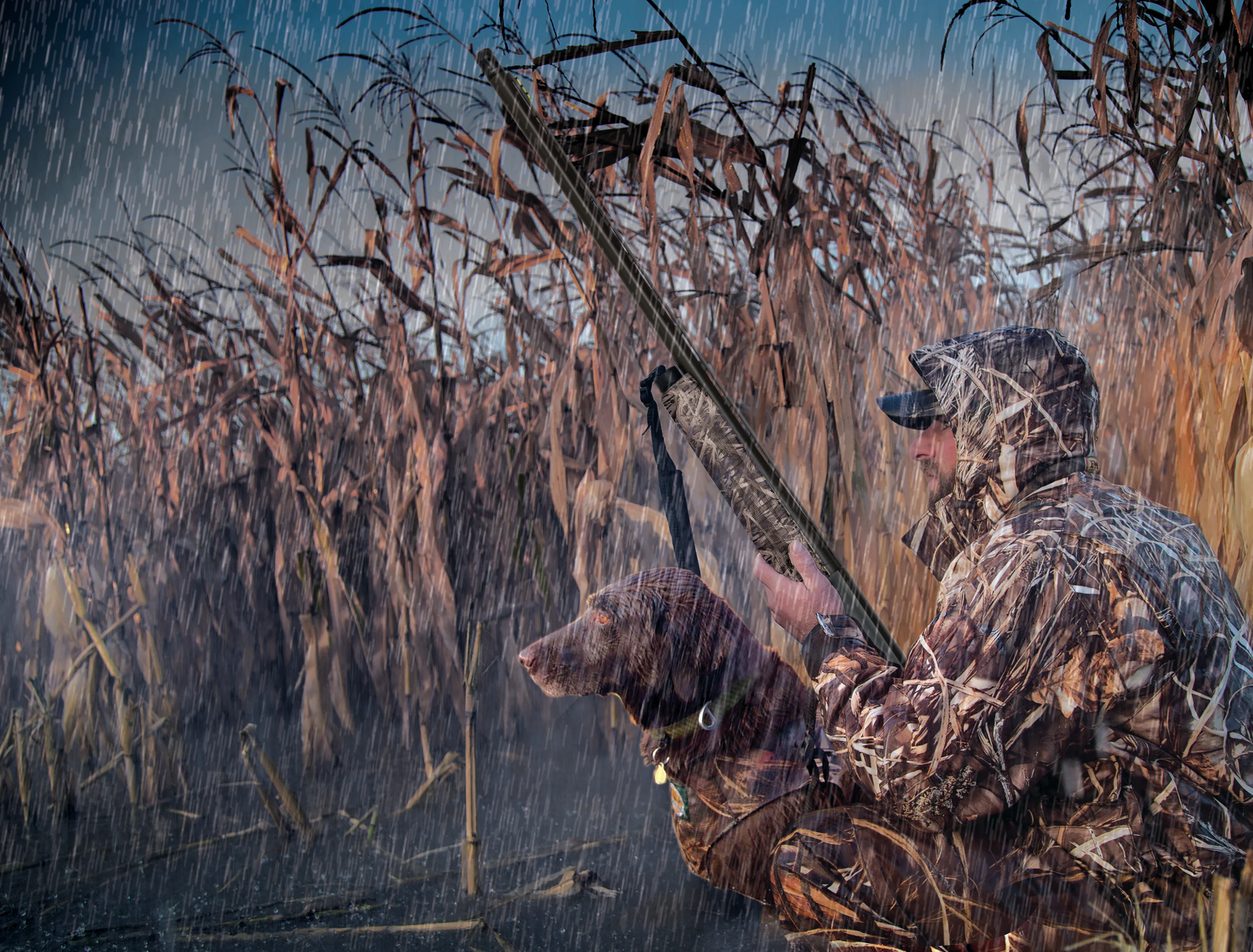 A hunter holds a Mossberg 940 Pro Waterfowl shotgun in the rain.