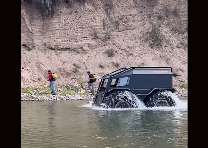 An amphibious vehicle drives through a Montana river.