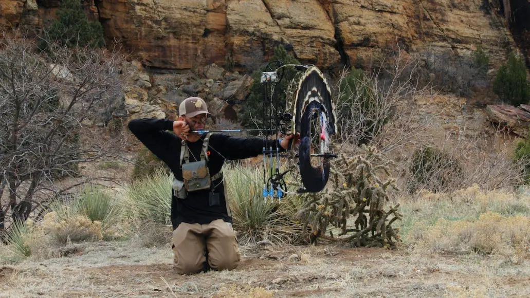 A hunter shooting a bow-mounted turkey reaping decoy.