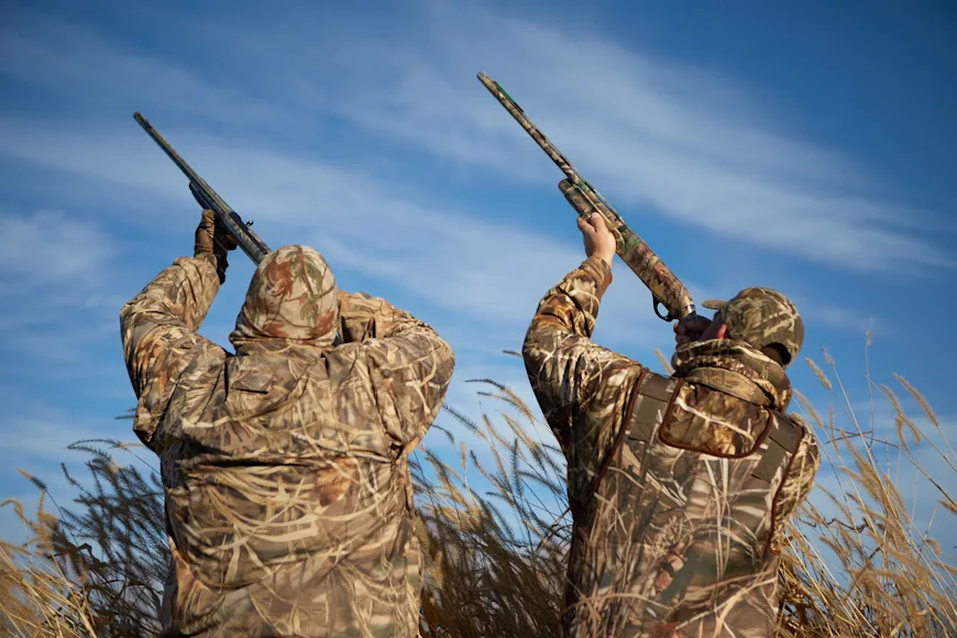 Two waterfowl hunters aim to the sky with gas and inertia shotguns.