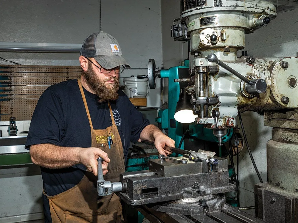 a gun smith using an extractor for a rifle barrel