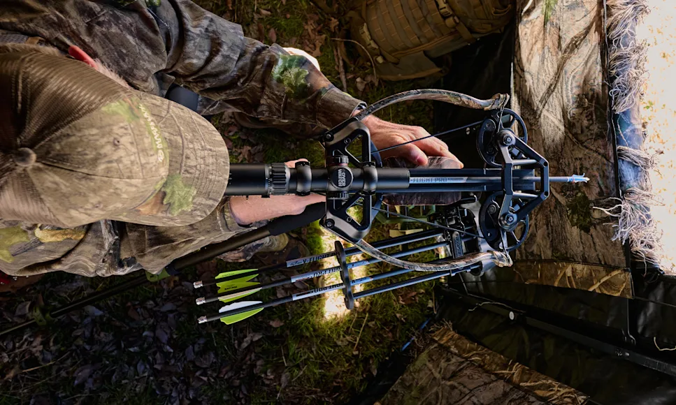 A hunter shoots the new Excalibur Hybrid X crossbow from a ground blind.