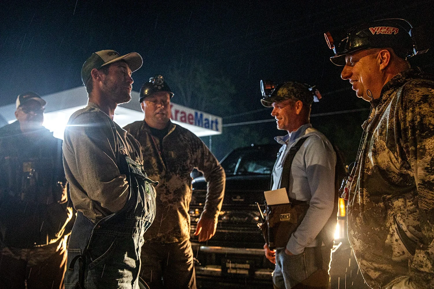 hunters with headlamps talking outside gas station at night