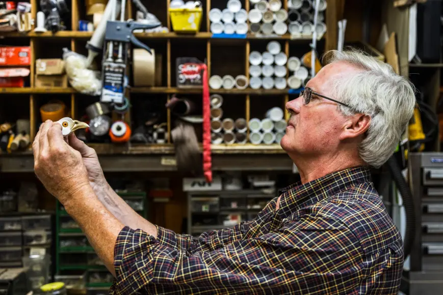 taxidermist looking at the head form for a pheasant mount.