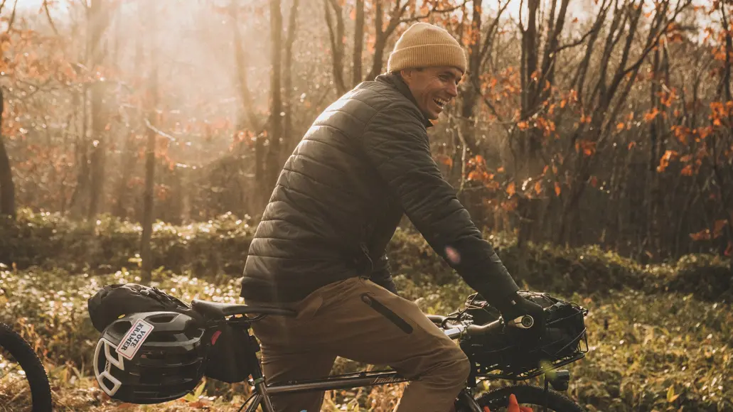 guy riding bike through the woods