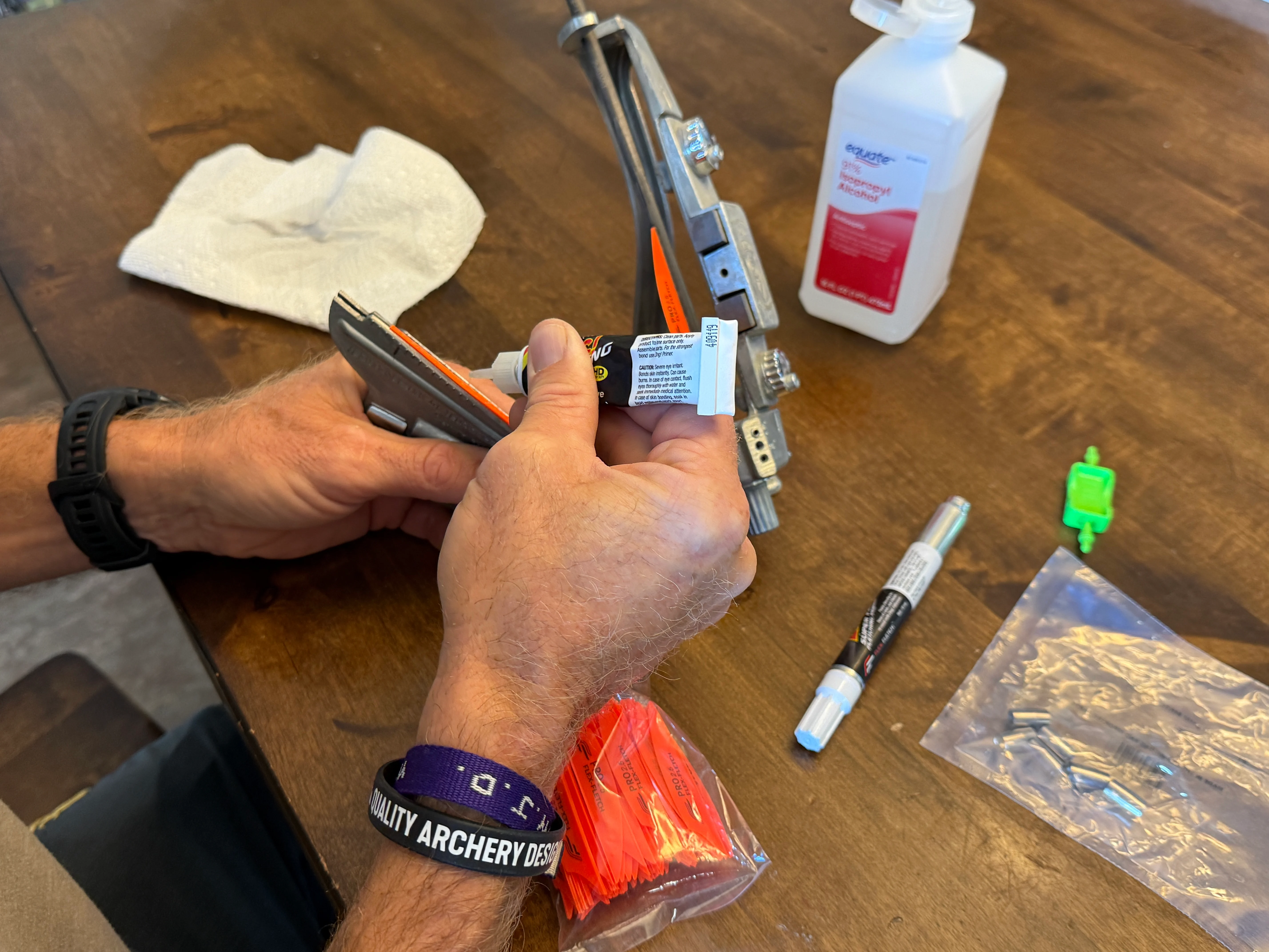 An archer applies glue to a vane while fletching arrows.