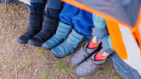 Campers sitting in hammock wearing Chaco puff camping slippers