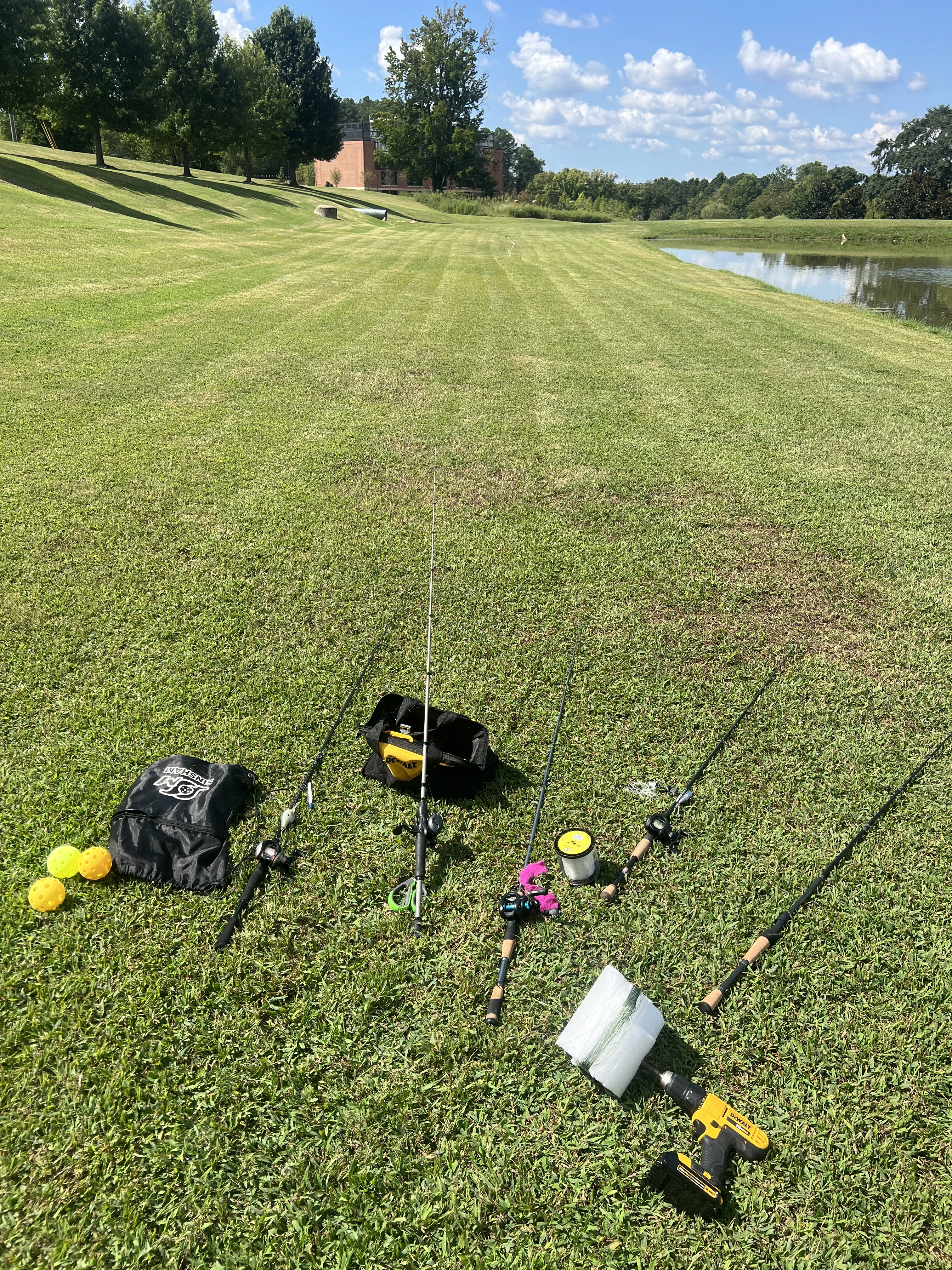 Fishing rods on a lawn next to a pond.