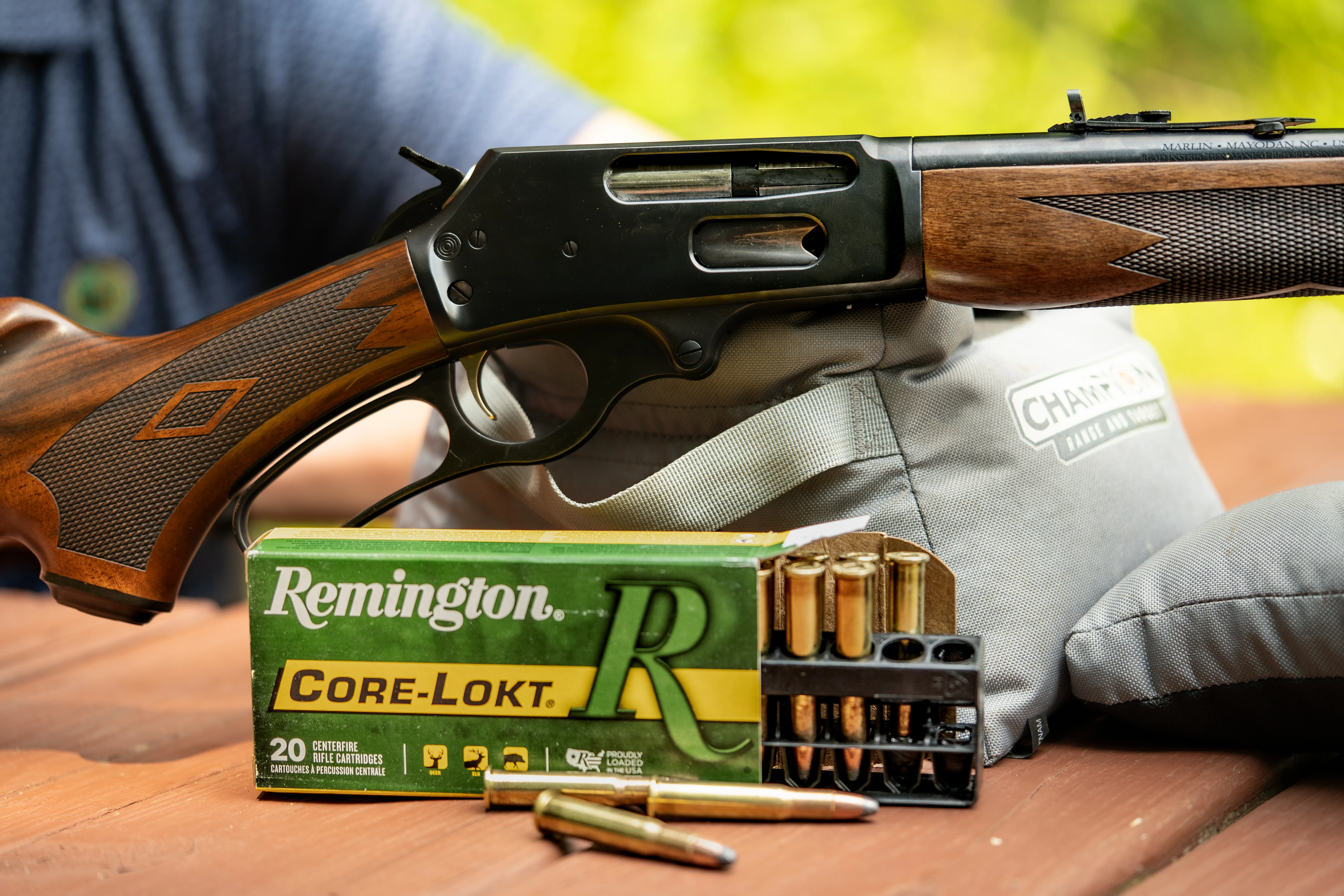 A 30-30 lever action on a shooting bench with Remington ammo. 