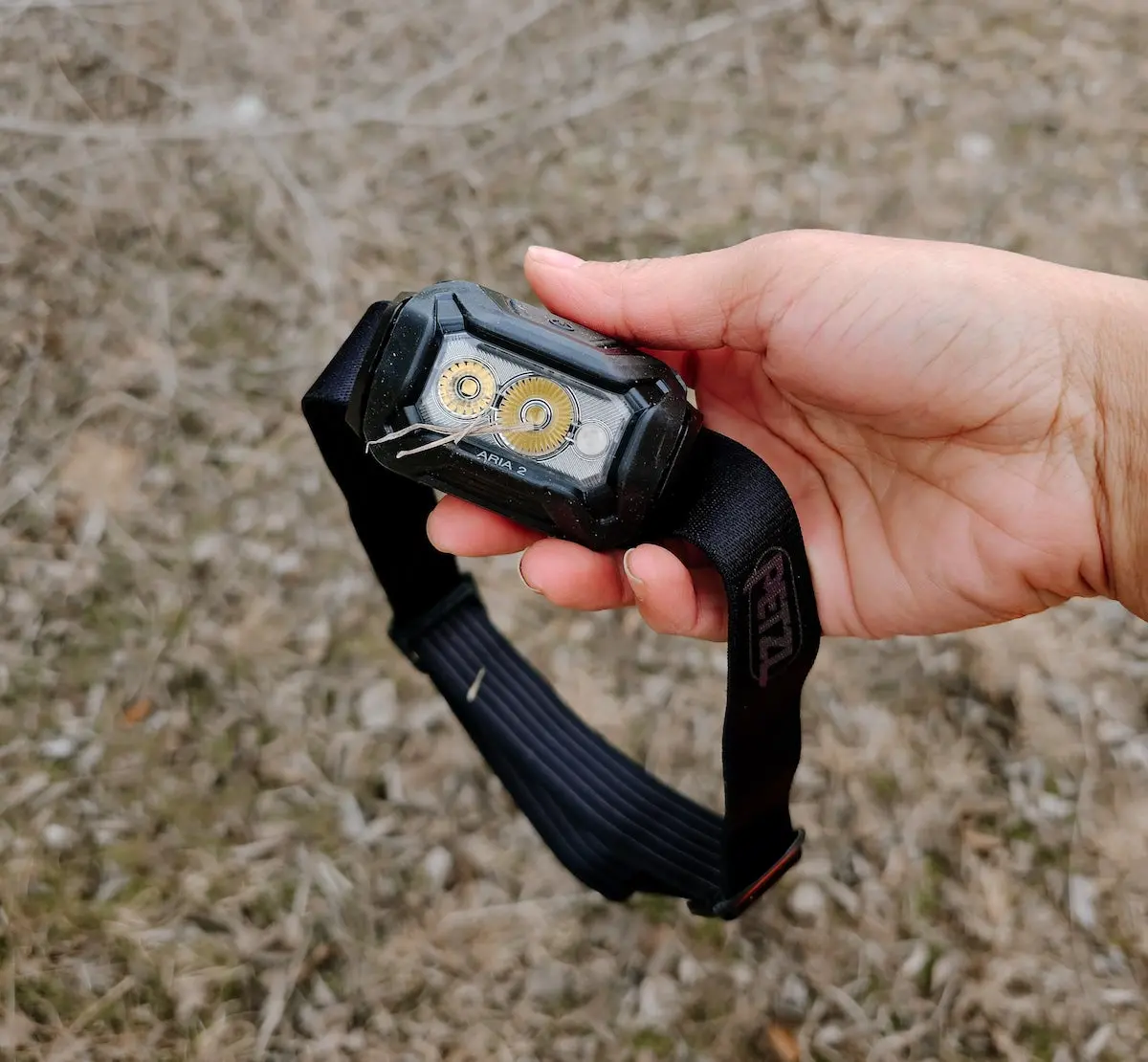 Woman holding Petzl Aria 2 RGB Headlamp