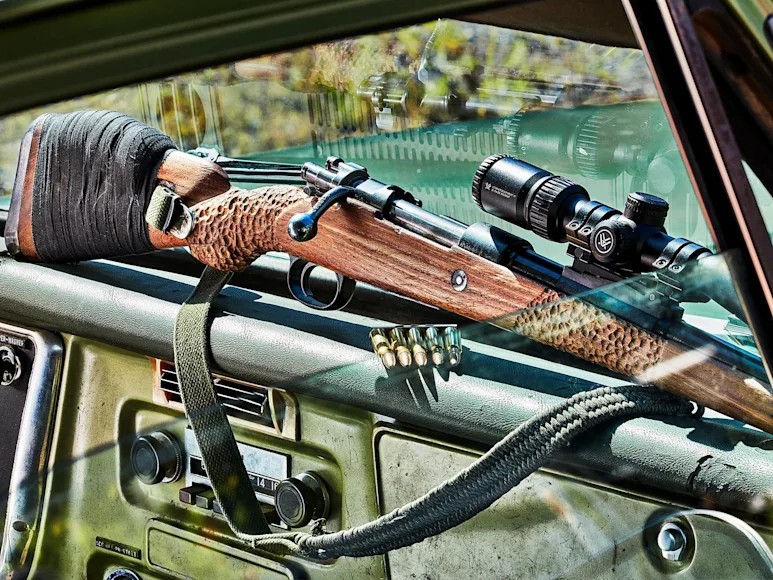 Scout rifle on the dash board of a pickup truck.