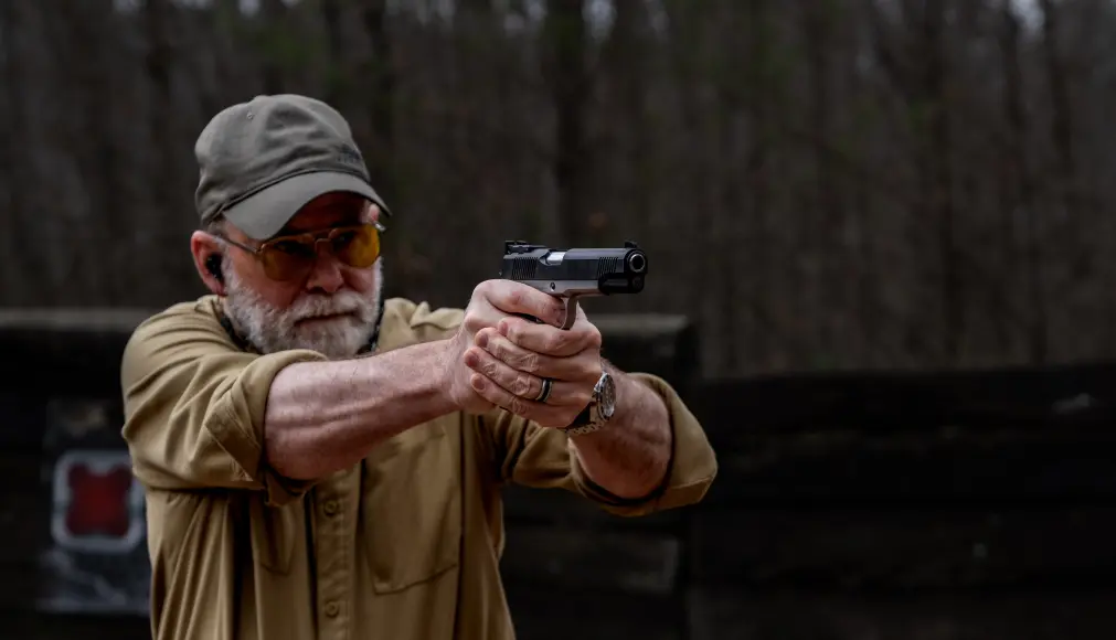 pistols vs handguns: Man shooting a handgun.