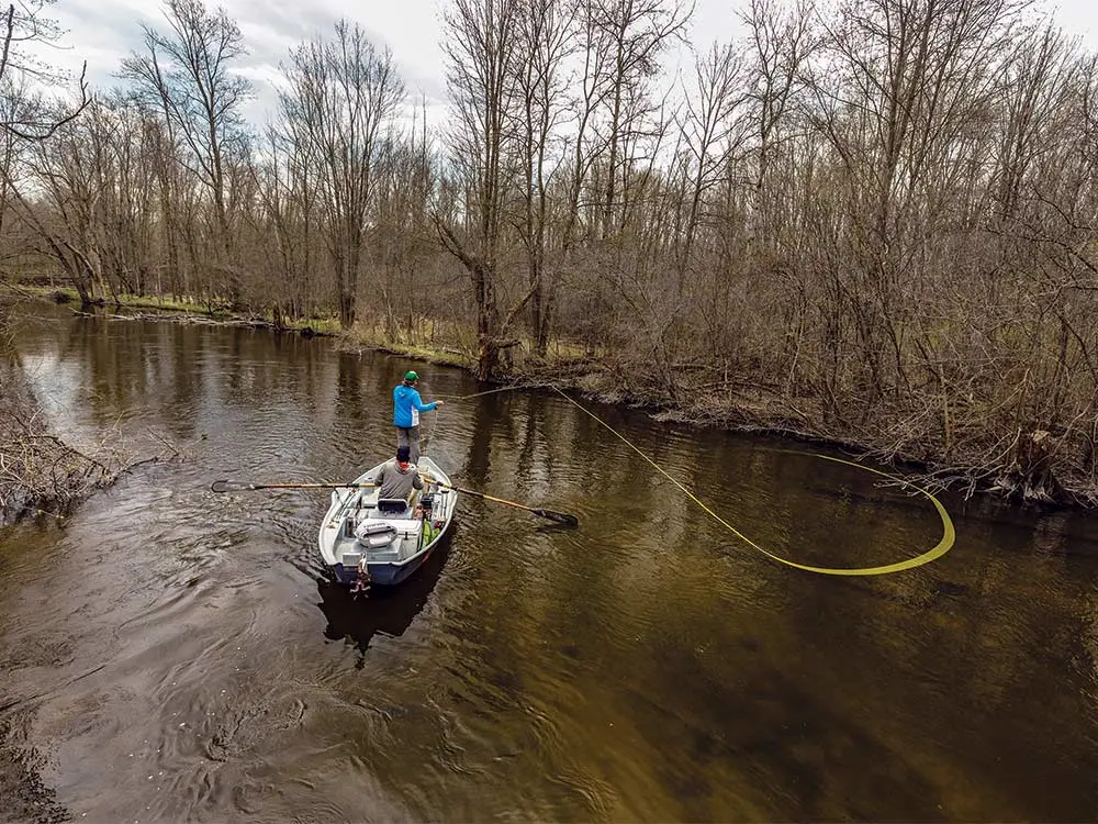 angler casting a fly line in a creek