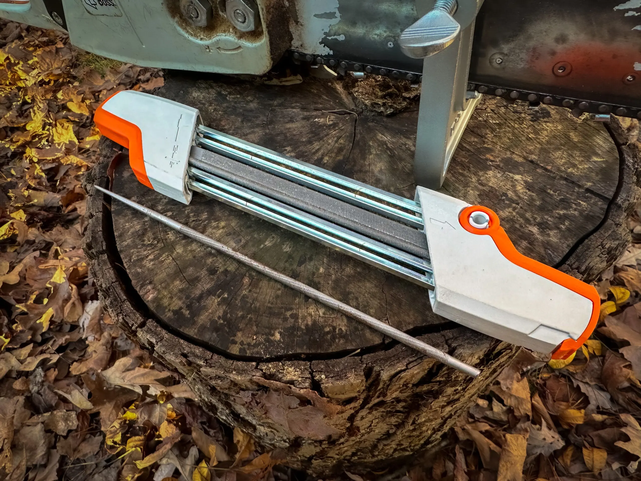 A file sharpener for a chainsaw sitting on a treestump