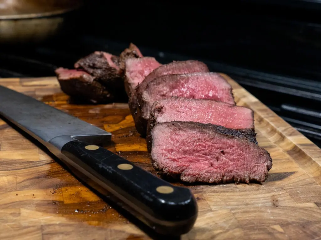 Venison loin cooked and cut with knife.