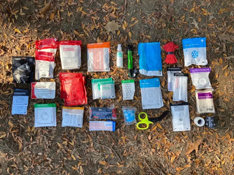 First aid kit components laid out on grass