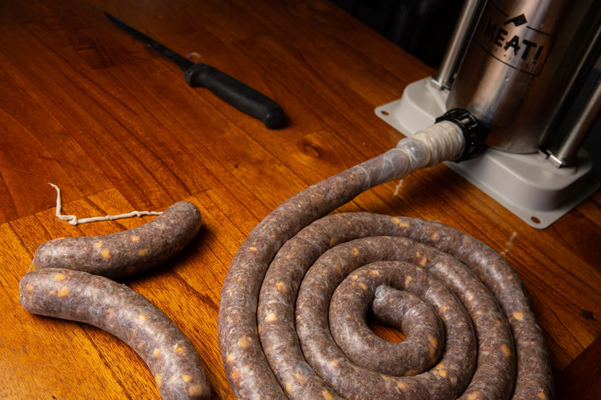 Sausage stuffer and sausage on a table.