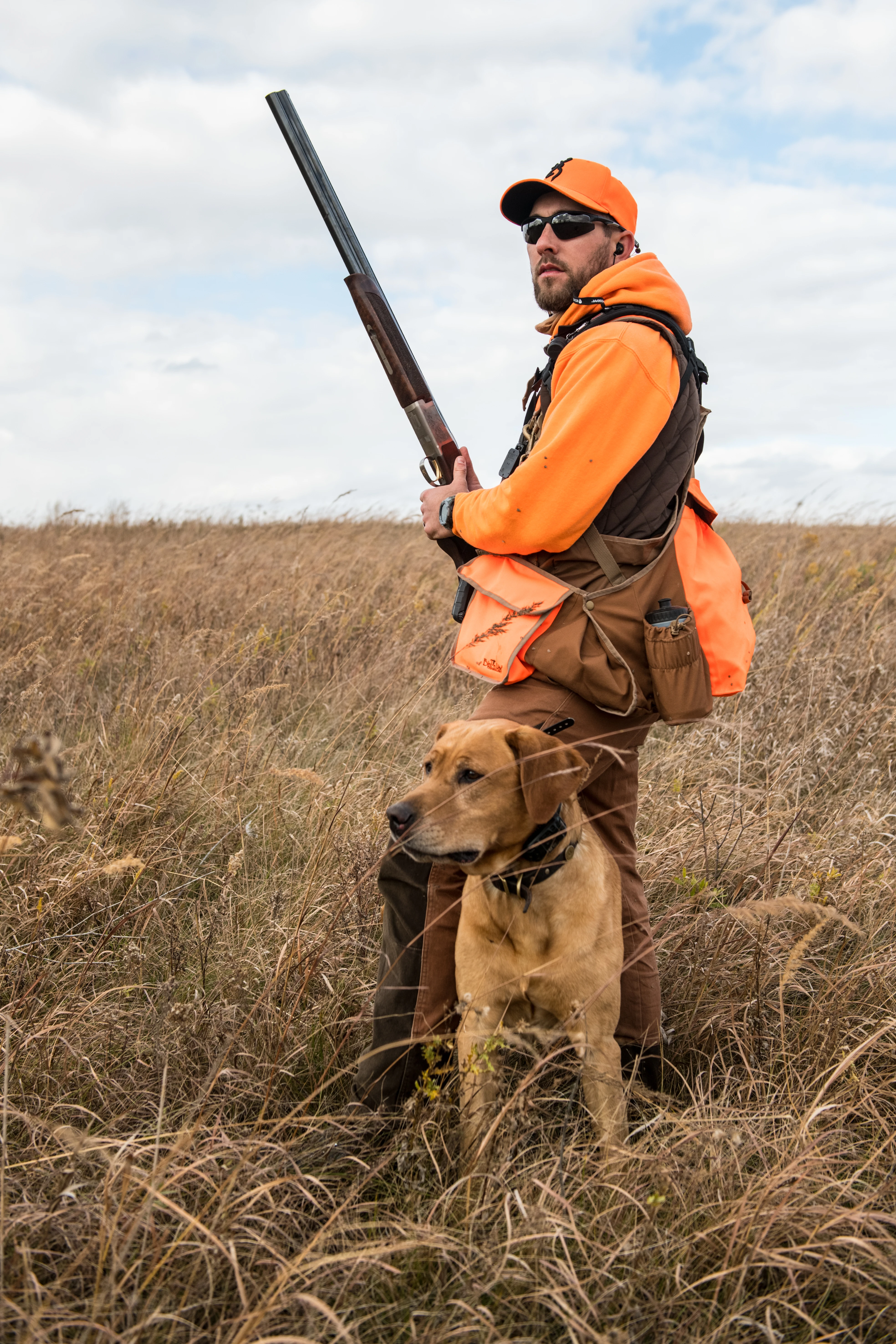 A hunter carries the Browning Citori 725 over-under shotgun in a field while pheasant hunting with his dog. 