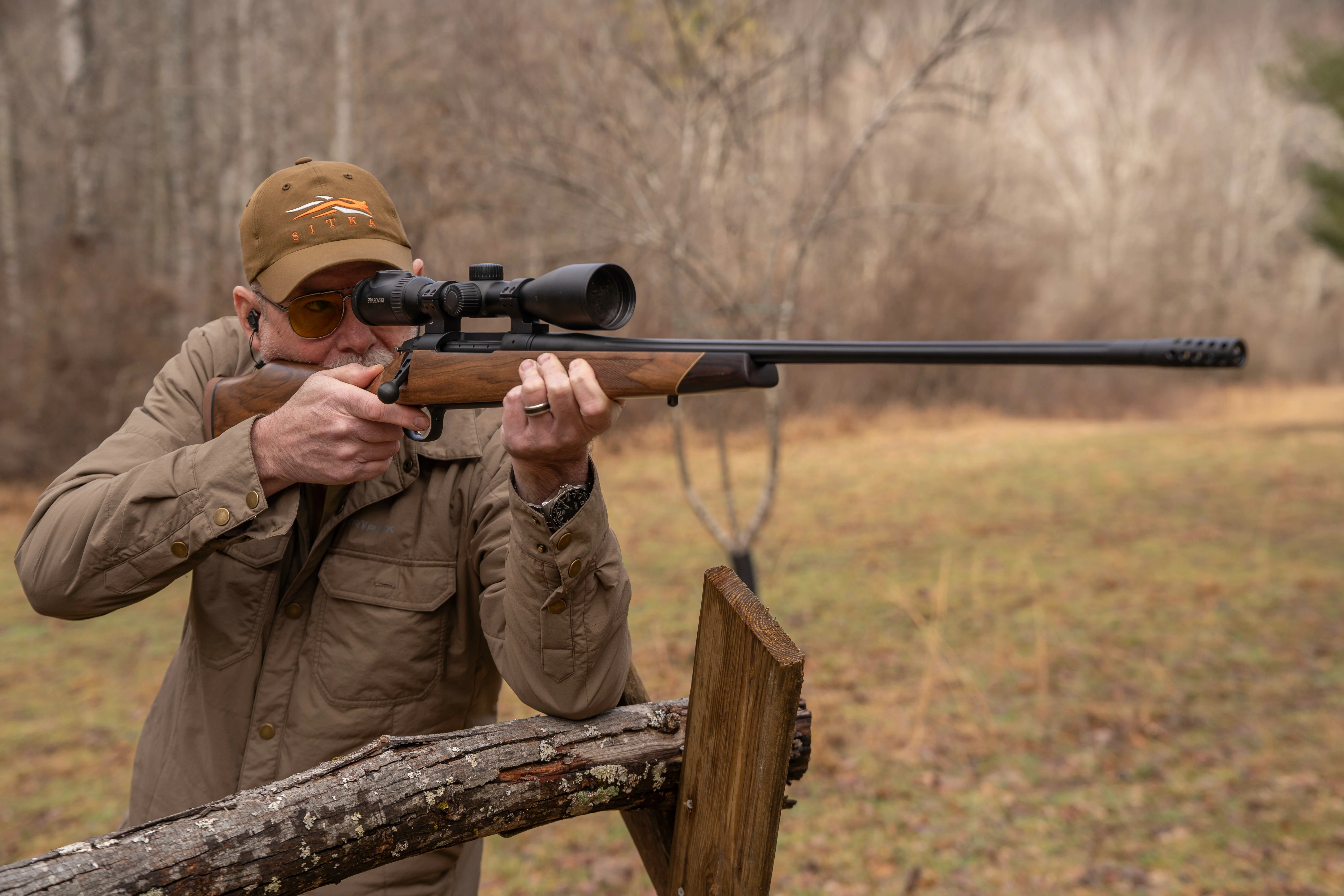 A shooter fires the new Weatherby Model 307 Adventure SD with an arm resting on a fence post. 