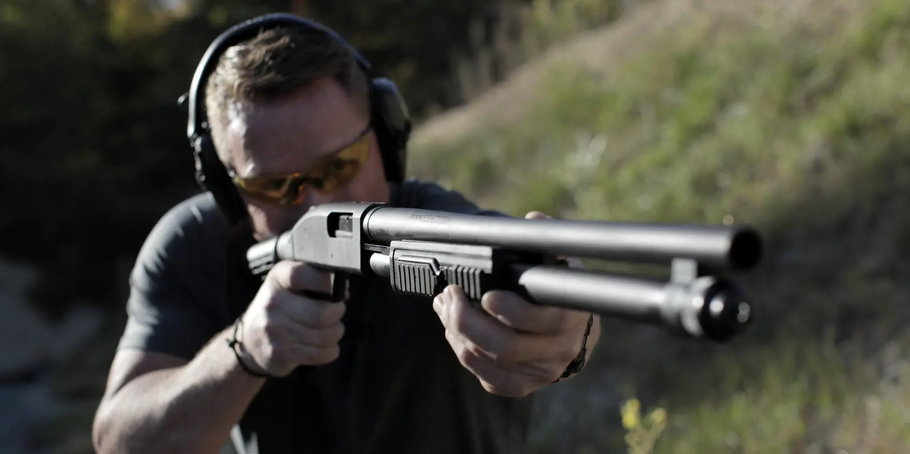 Photo of a shooter aiming a Mossberg 590