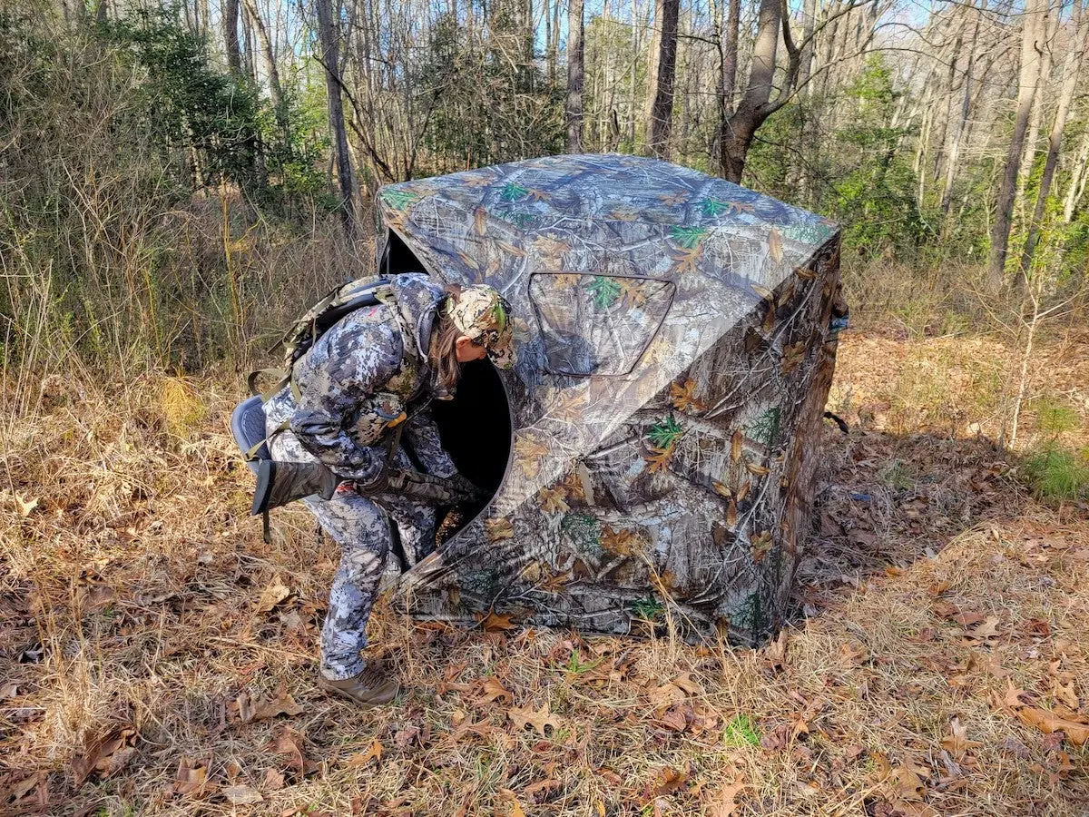 Female hunter entering Game Winner Bushwhacker Hub blind for turkey hunting