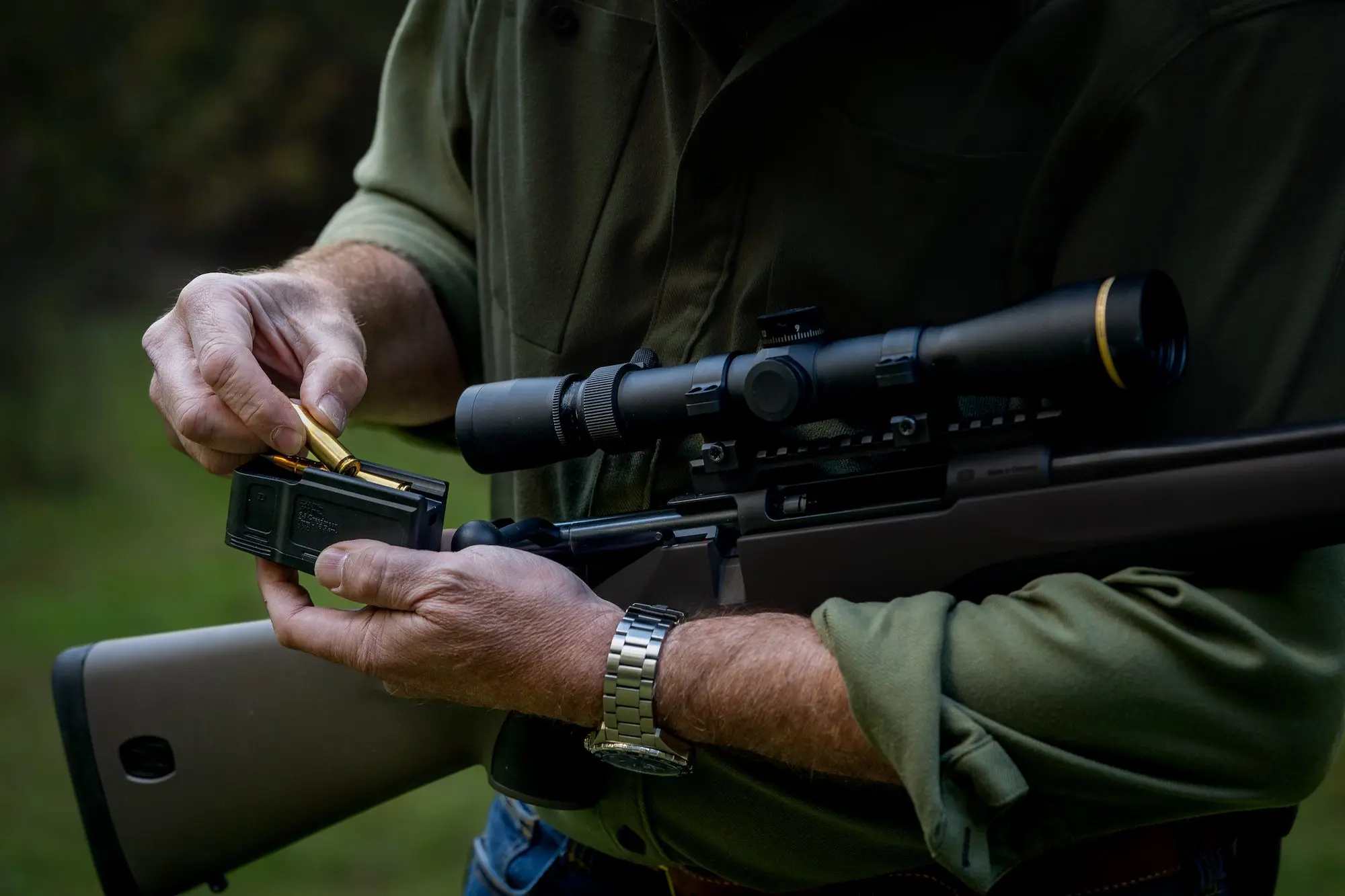 Man loading magazine full of cartridges.