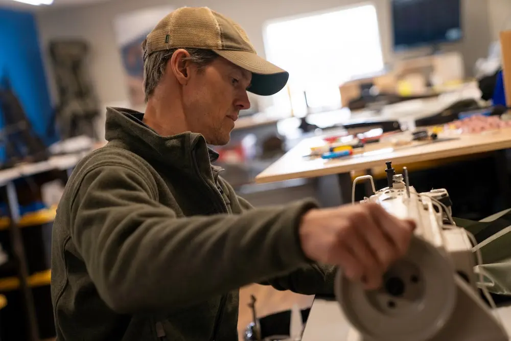 Stone Glacier founder Kurt Racicot sewing a backpack