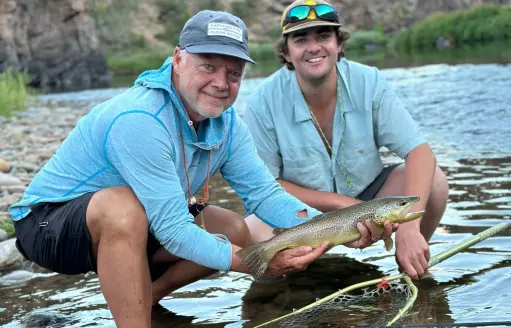 fly fishermen holding brown trout