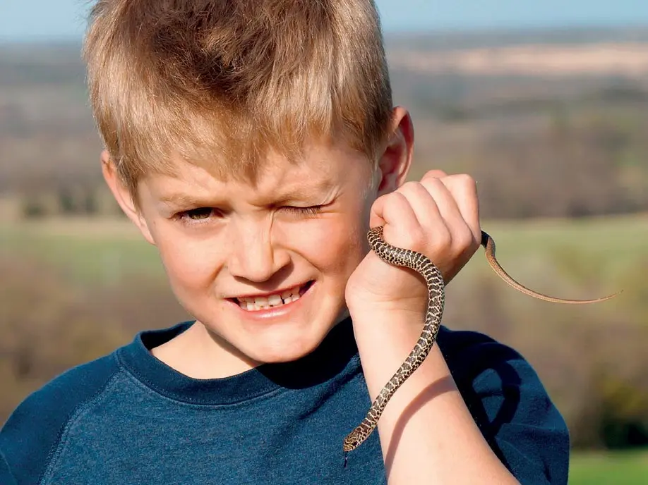 child holding a snake