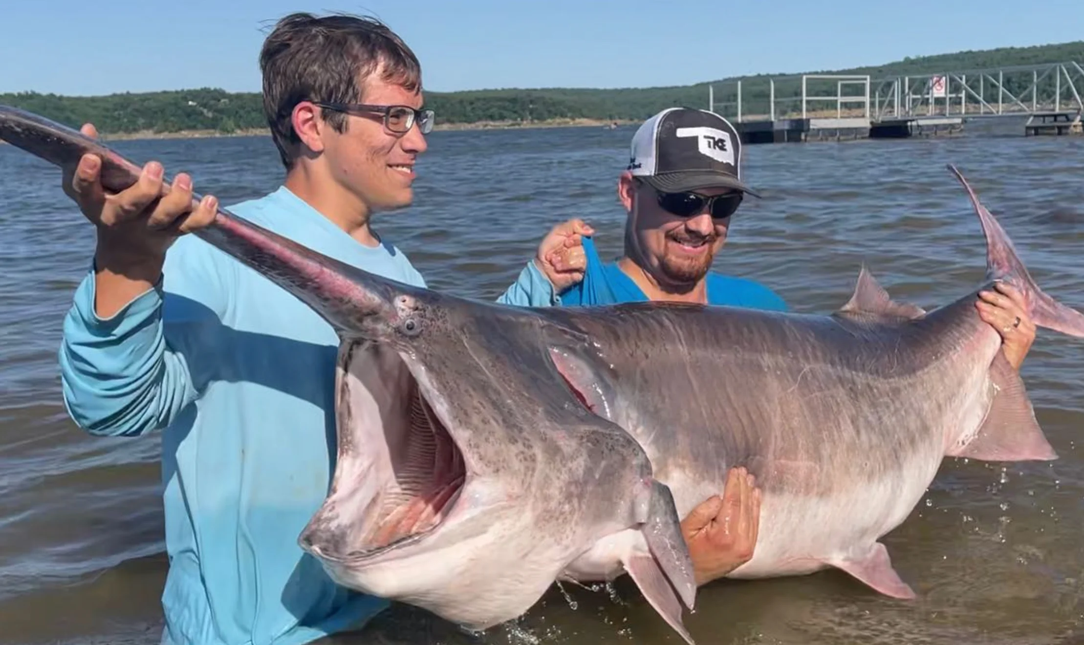 An angler poses with a record-breaking paddlefish in Oklahoma.