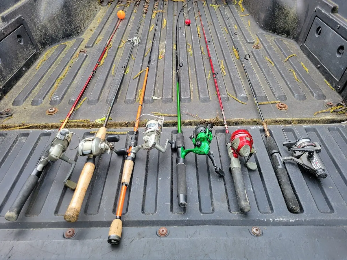 Fishing rod and reel combos laying on truck tailgate