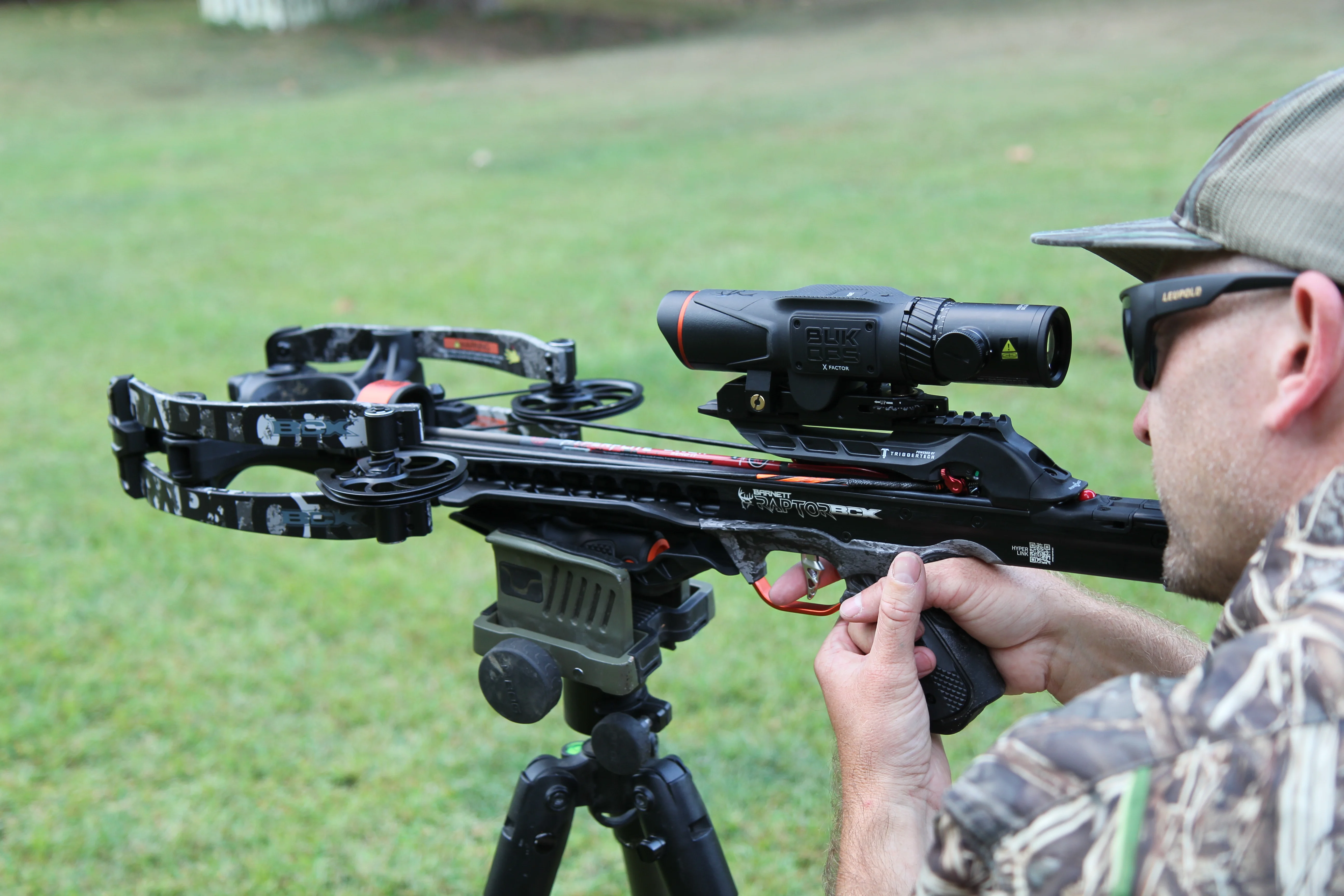 A shooter fires theBarnett Hyper Raptor BCX BukOps crossbow in a back yard. 