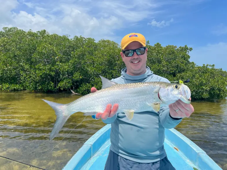 Colin Kearns holds a small tarpon