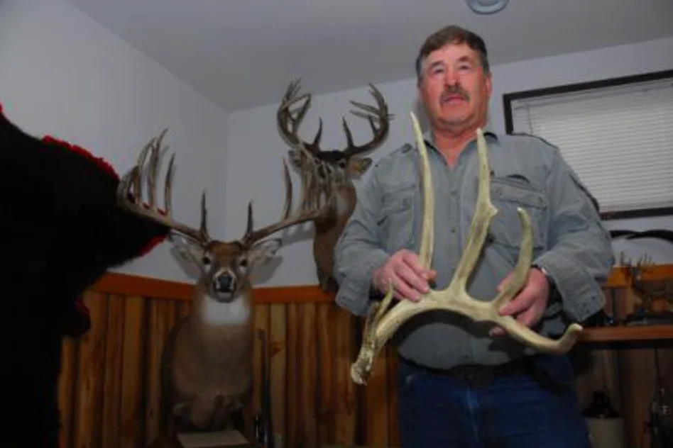 A deer hunter poses next to a world record whitetail. 