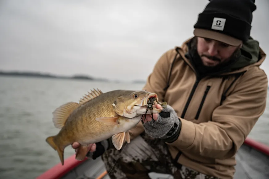 Angler holding largemouth bass over water