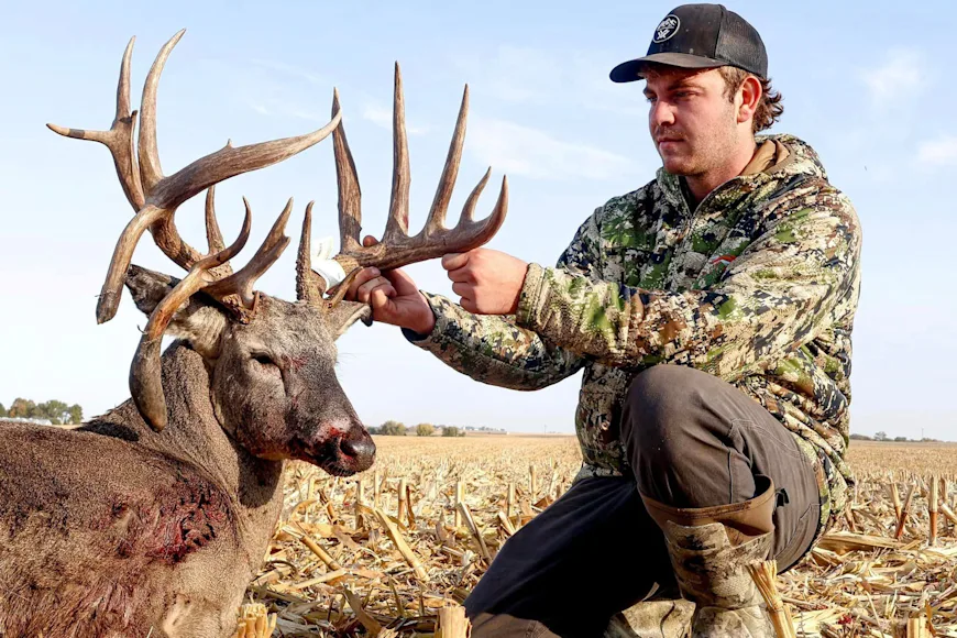A bowhunter admires the 19-point rack of a trophy whitetail taken in Iowa.