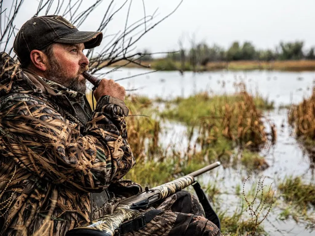 Hunter calling in ducks on a lake.
