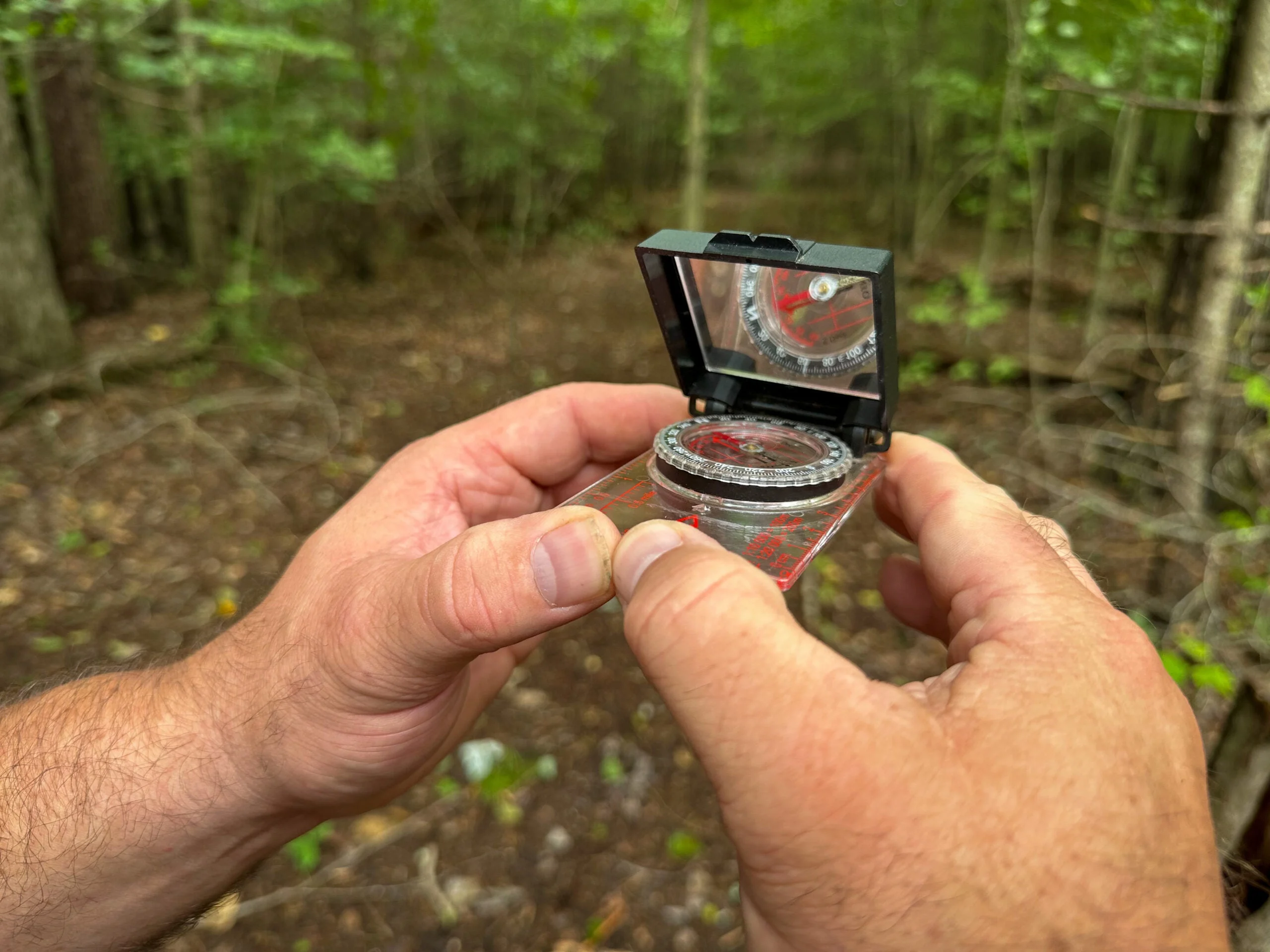 hiker shows how to use a compass