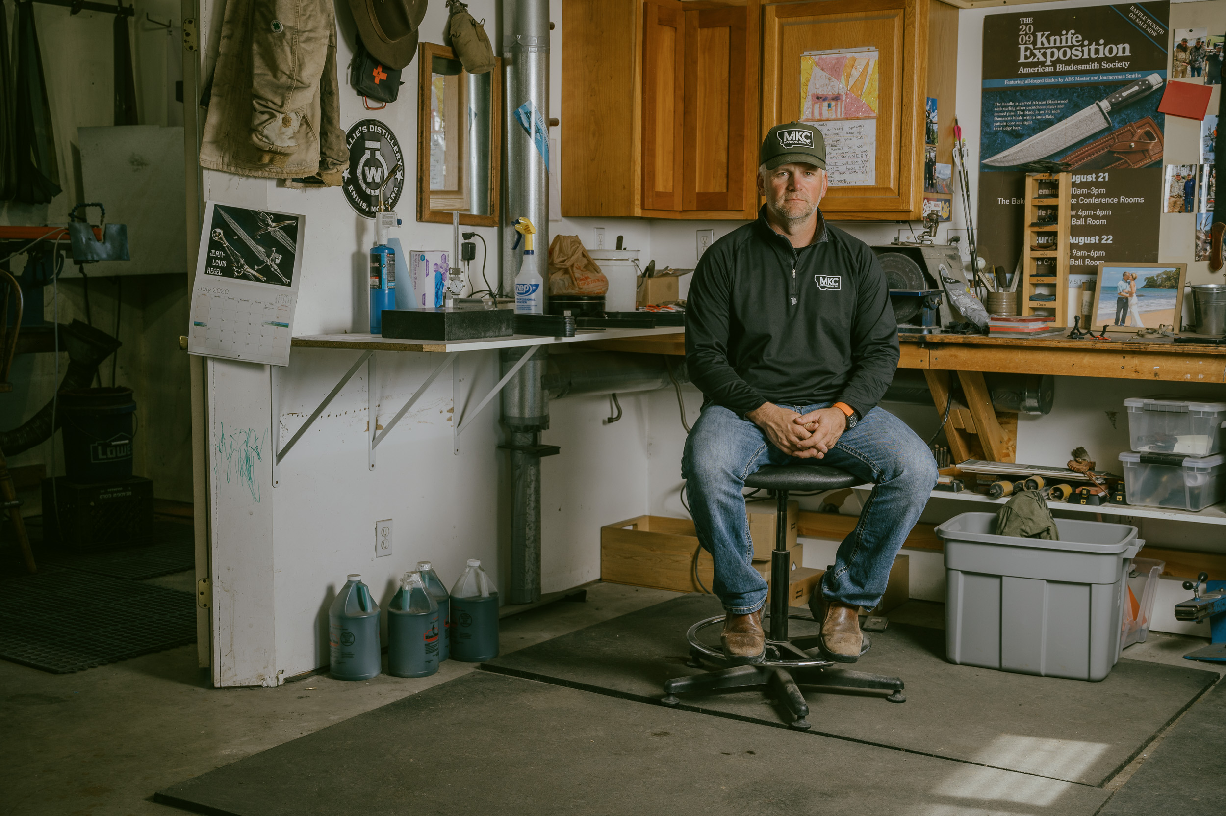 Josh Smith sits at a work bench in his Montana knife shop. 