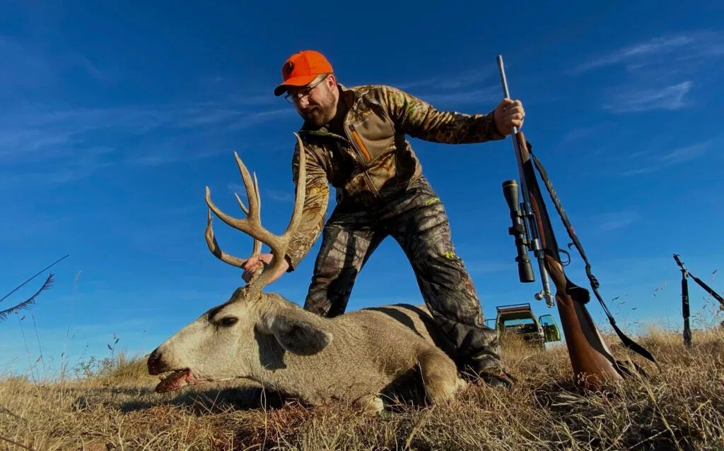 Hunter with mule deer buck