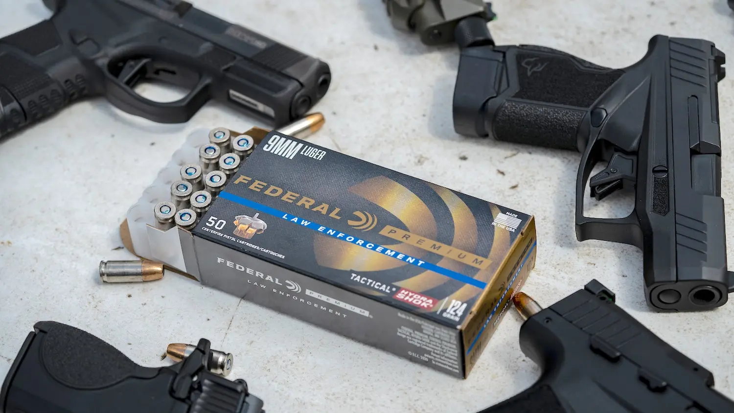 Handguns and ammo on a table. 