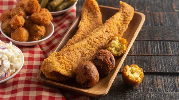 a plate of fried catfish with hushpuppies