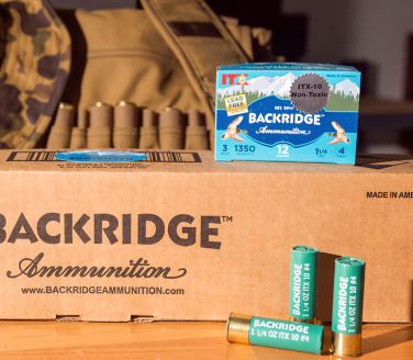 A box of shotgun shells on a wooden table and box.