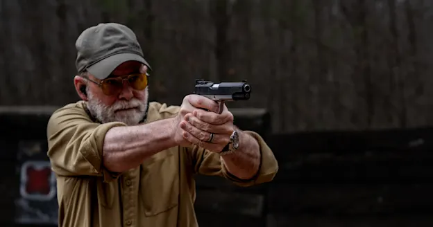 the author fires a 1911-style pistol on the range