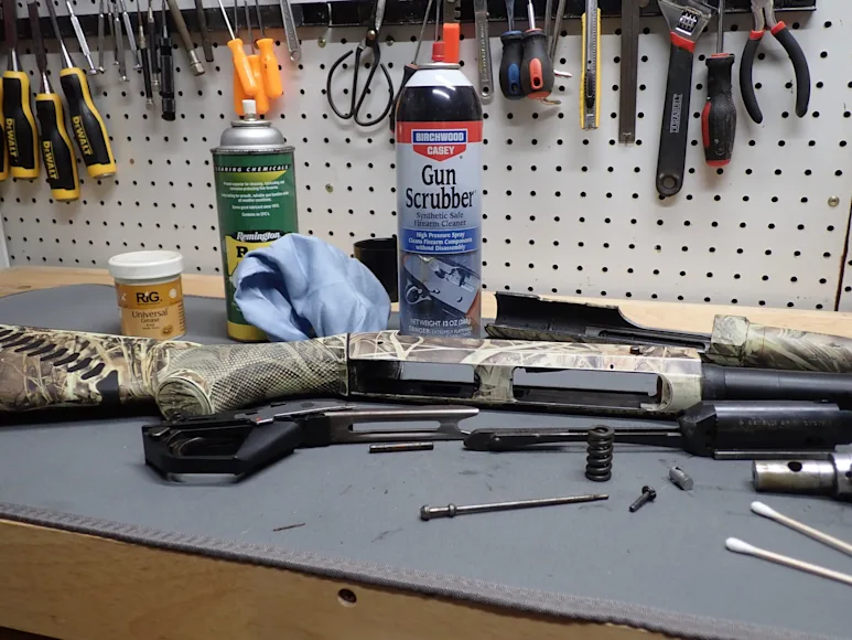 disassembled shotgun on work bench.